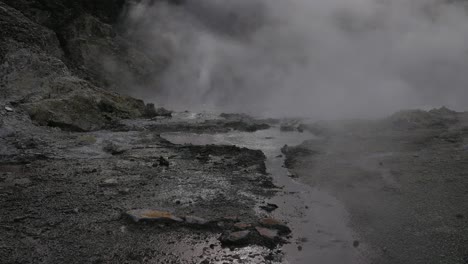 Boiling-hot-geothermal-volcanic-mud-pool,-closeup-shot-steamy-lake-bubbling-mud-and-steam-landscape-slow-motion