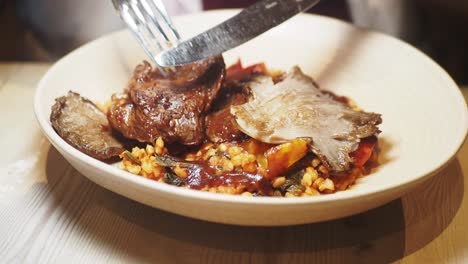 person eating a meal with steak, mushrooms, and rice