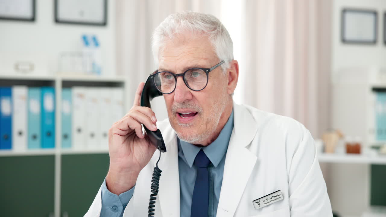 Senior Doctor Talking on Landline Phone in Clinic Office
