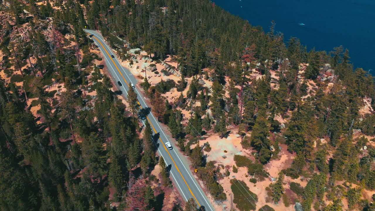 Motorway through the rocky landscape on sunny day. Roads going by the highway on the mountainous shore of Lake Tahoe.