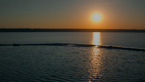 Luftaufnahme-Des-Ruhigen-Ozeans,-Der-Den-Goldenen-Sonnenuntergang-Am-Abend-Reflektiert.-Drohnen-Seelandschaftsinsel