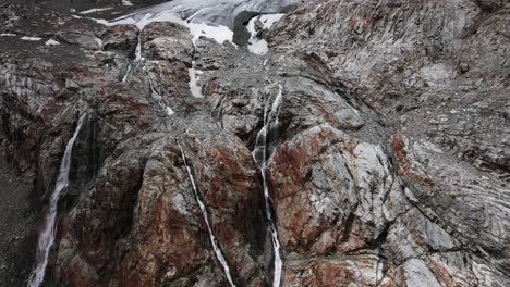 impressive panoramic view of glacier and many waterfalls falling down mountain walls of fellaria in valmalenco, italy