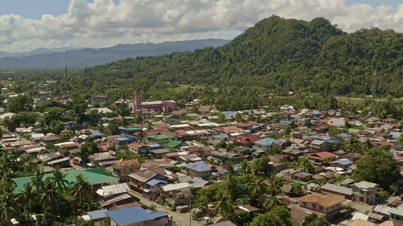 Gerakan kamera ke atas memperlihatkan kota pesisir Bacuage di Surigao Del Norte untuk menampilkan lanskap hutan di belakangnya