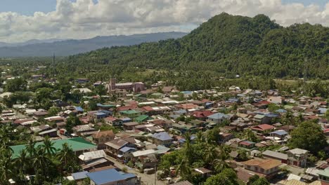 Vista-Panorámica-Sobre-La-Ciudad-Costera-De-Bacuage-En-Surigao-Del-Norte-Para-Revelar-El-Paisaje-Selvático-Detrás