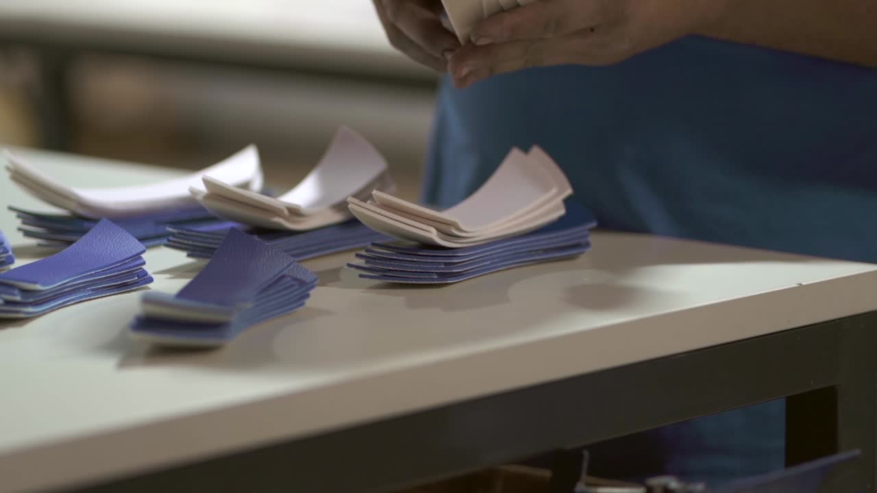 Factory worker sorts out all cutted volleybal fabric material shapes on her worktable