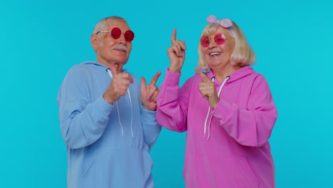 Lovely-senior-couple-man-woman-grandparents-listening-music-dancing-disco-fooling-around-having-fun