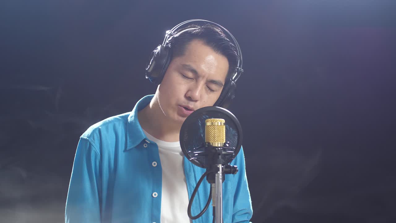 녹음 스튜디오 에서 마이크 로 노래 하는 남자