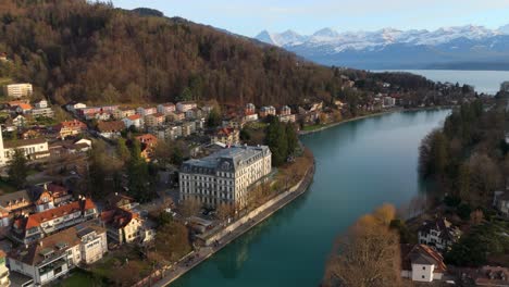 historic thun town on aare river, alpine lake thun landscape beyond