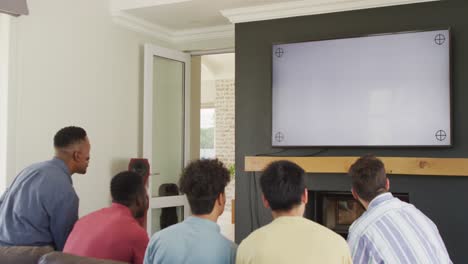 felices amigos varones diversos viendo televisión con espacio de copia en la sala de estar