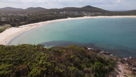 fingal bay with white sand beach in summer. barry park lookout revealed. nsw, australia. aerial pullback shot