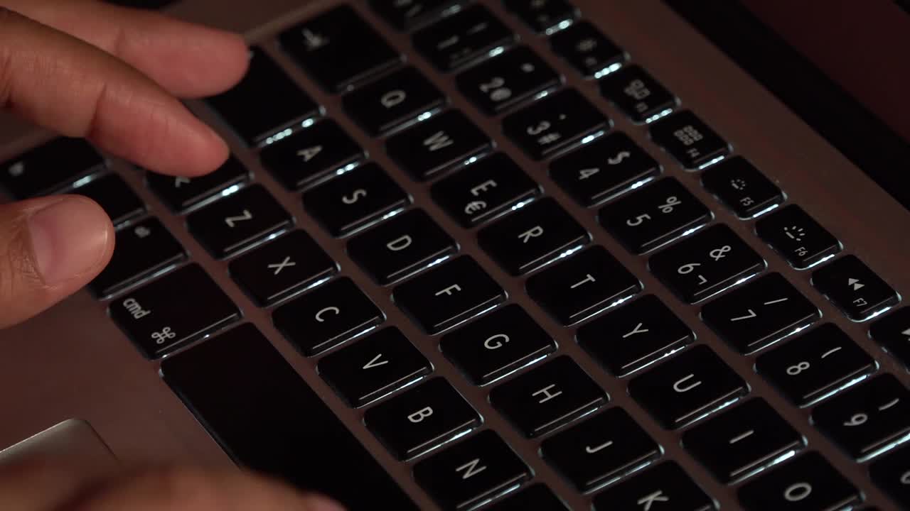 Hands typing on a laptop keyboard
