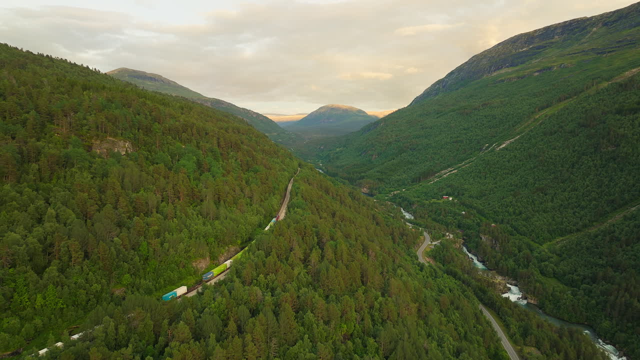 vista aérea de un tren de carga a través del exuberante valle de romsdalen, noruega