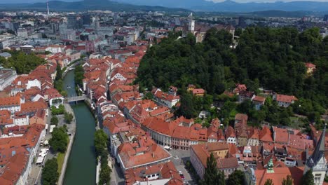cinematic drone aerial view of ljubljana old town and ljubljana castle with mountains in the background