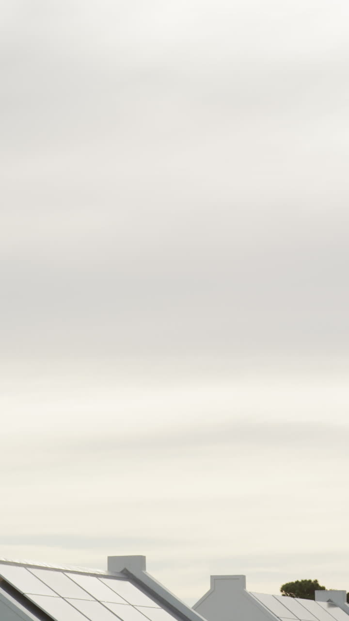 video vertical de cielo azul y nubes sobre casas blancas