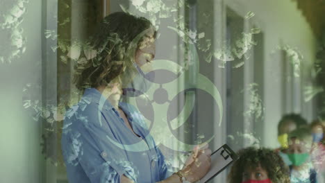 animación de las celdas de señal de peligro biológico covid-19 y las maestras y los escolares con máscaras faciales