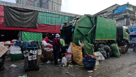 trabajadores cargando basura en un camión de basura