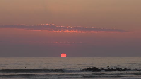 Relajante-Amanecer-En-La-Playa-Con-Nubes-Iluminadas-Por-El-Sol,-Mar-Mediterráneo