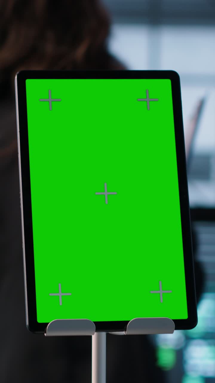 Vertical video Close up of chroma key tablet next to coworkers examining data center