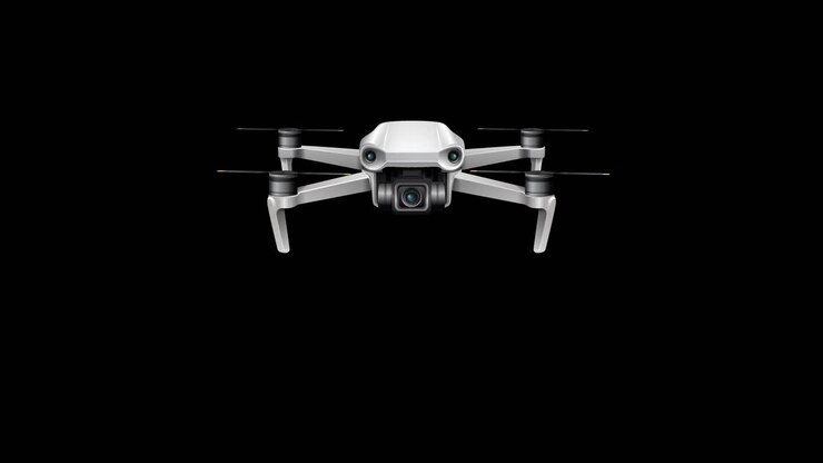 A drone smoothly advances towards the viewer against a black background, highlighting its sleek design and movement