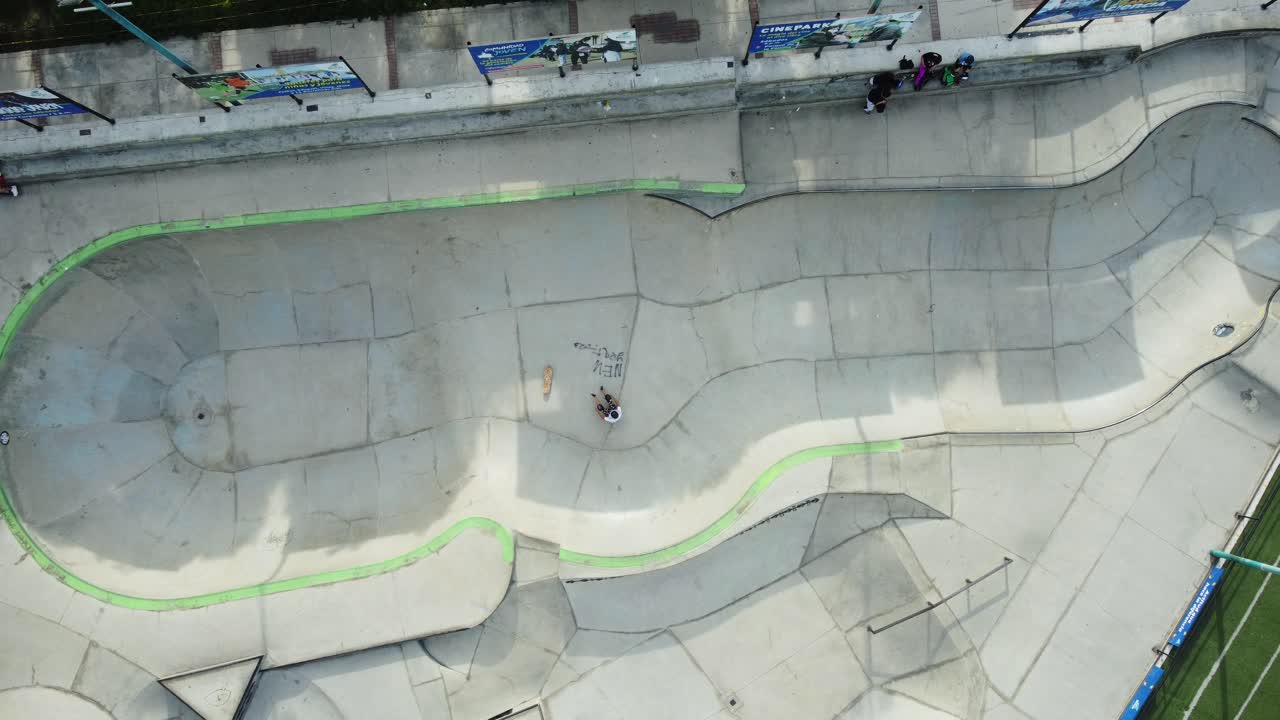 스케이트파크 수영장에서 스케이트보더의 탑다운 드론 영상