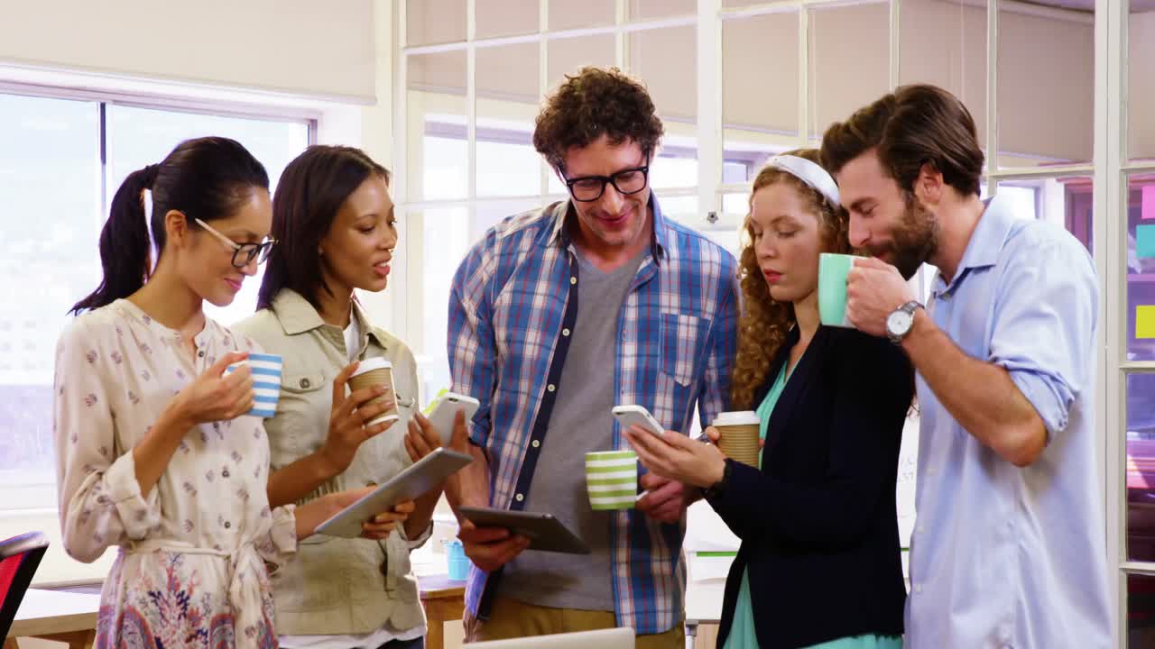 grupo de ejecutivos de negocios tomando café mientras interactúan a través de una tableta digital