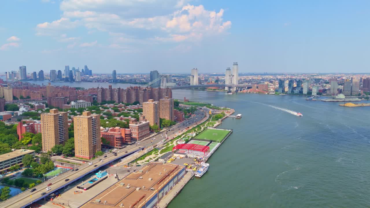 Aerial view of Manhattan waterfront and Williamsburg Bridge, Pier 36, NYC, USA. Aerial forward