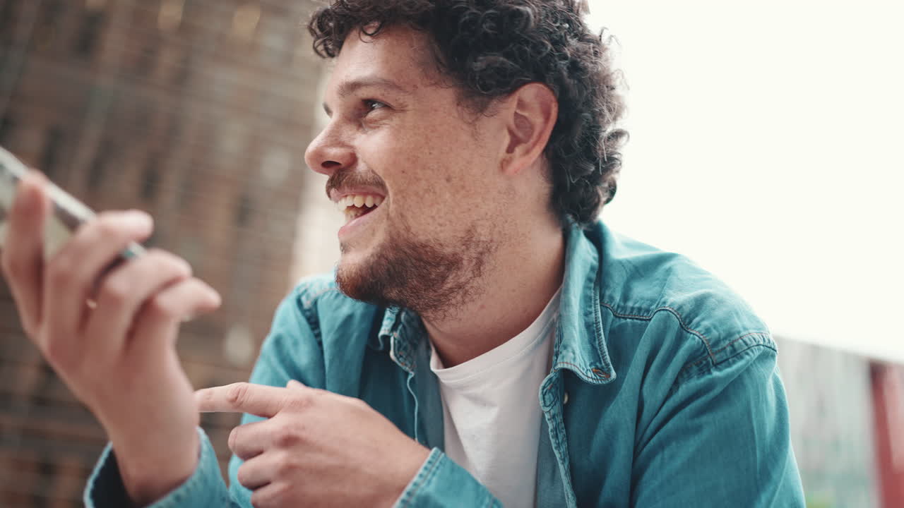 Man with Curly Hair Talking on Smartphone