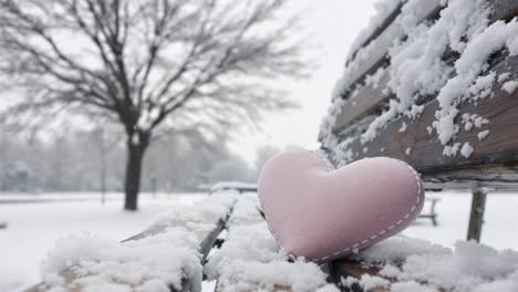 pink heart on a snowy bench in winter