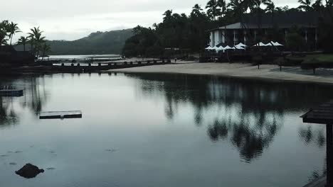 drone flying towards fiji beach hotel the warwick at sunrise