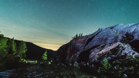 Starry-night-sky-time-lapse-in-mountain-Alps-with-trees-and-wispy-clouds,-astrophotography