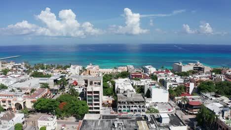 wide aerial shot flying over playa del carmen towards the caribbean sea in quintana roo, mexico