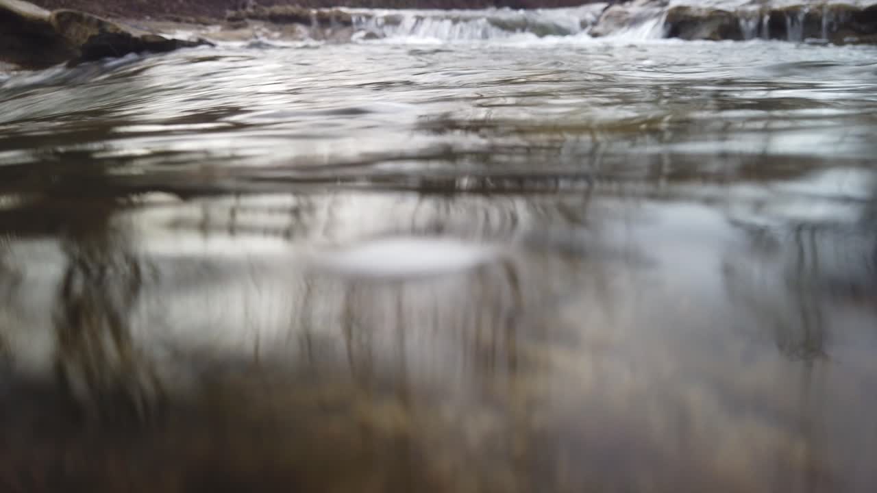 Ruscello d'acqua di fiume limpida e scorrevole.