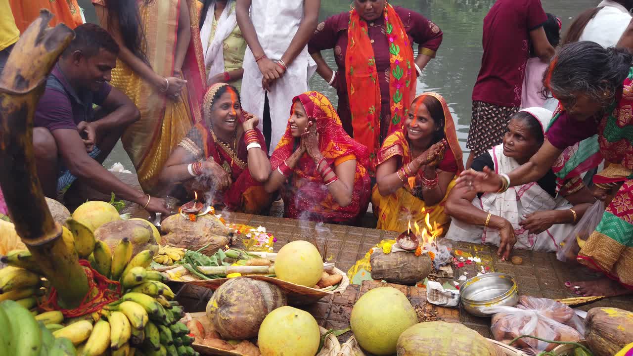 Shot of the people siting on the steps of ganga river water doing Hindu wedding rituals with fruits and puja items in Kolkata.