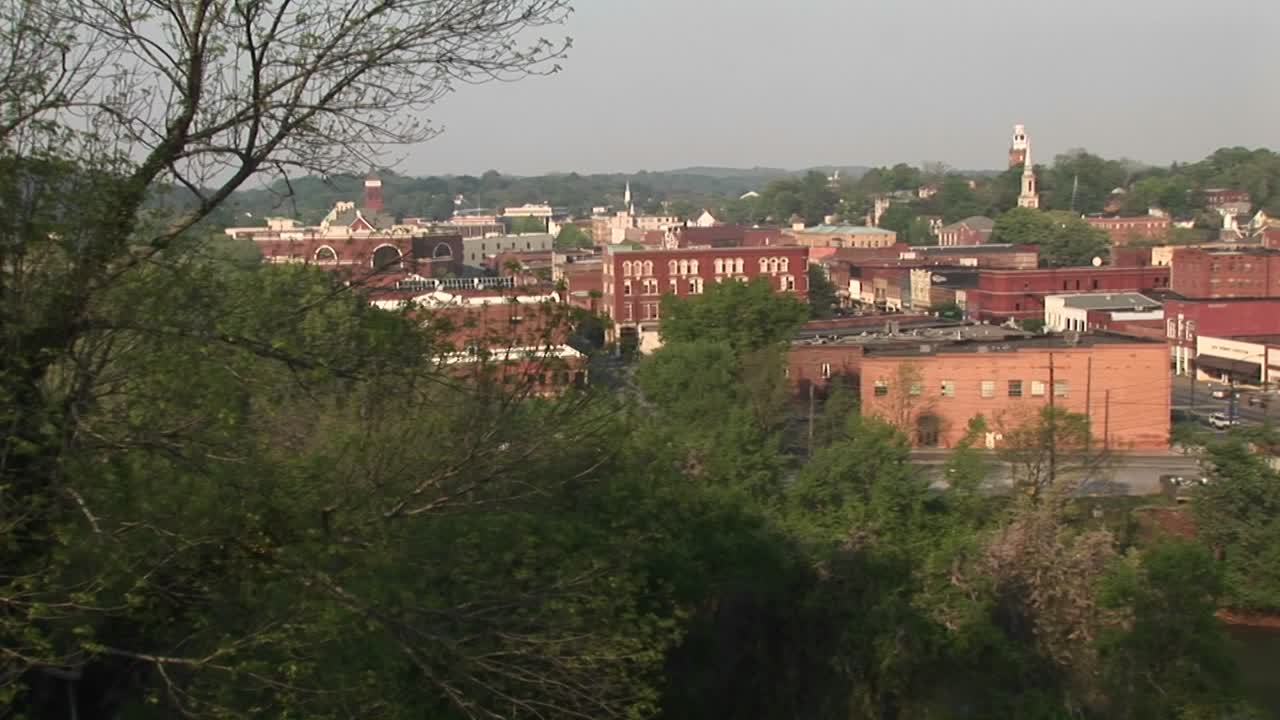 la cámara gira a la derecha para ver los edificios y un puente de tráfico en un pequeño pueblo de montaña