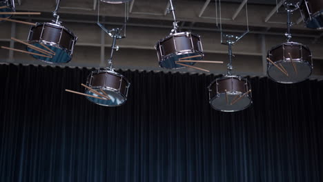 drums hanging upside down from the ceiling with sticks