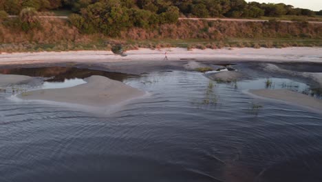 Rothaarige-Frau,-Die-In-Der-Dämmerung-In-Uruguay-Am-Sandstrand-Der-Laguna-Negra-Spazieren-Geht