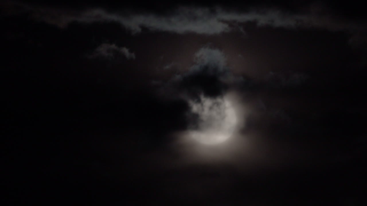 Full Moon Shining Through Clouds at Night