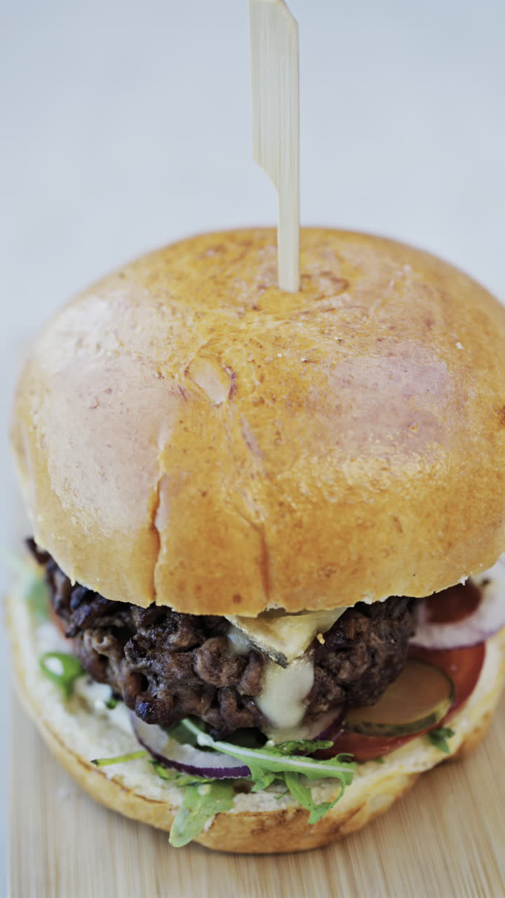 Close up of a hamburger on a plate at a restaurant. Vertical