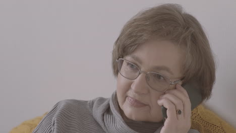 senior woman with eyeglasses talking on the phone