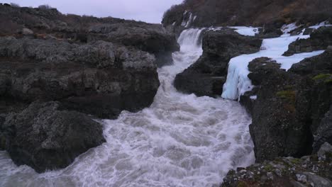 turbulent foamy water in wild river flowing through the mountain rocks