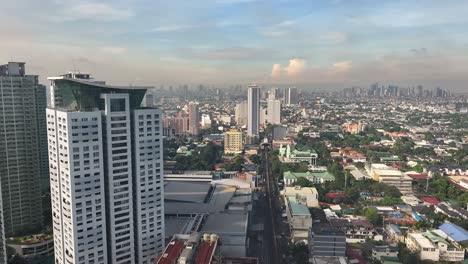 vuelo aéreo a lo largo de la torre en el distrito suburbano de la ciudad de manila y el horizonte en el fondo - humo gris oscuro volando en el cielo