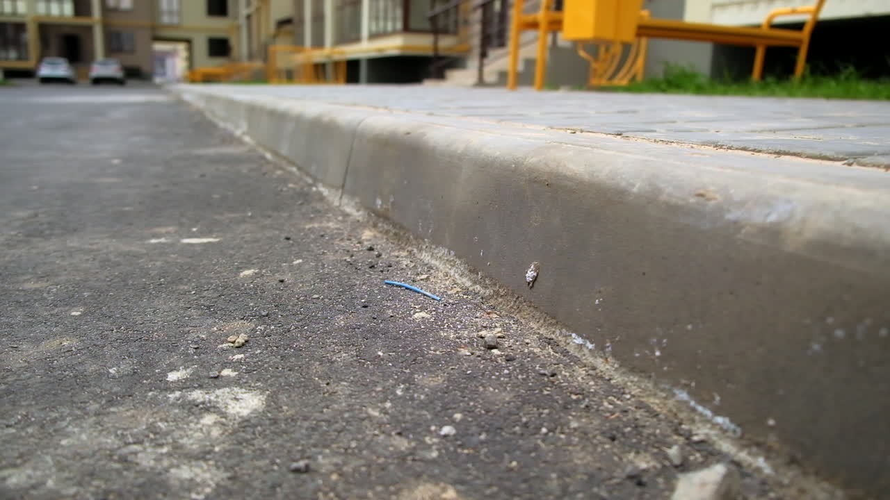 Close-up of a curb in front of residential buildings
