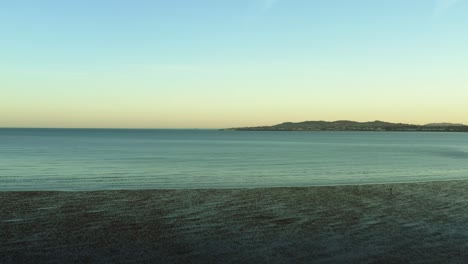 Aerial-of-Beautiful-low-tide-at-Dublin,-Ireland-coast-at-sunset,-dolly-in