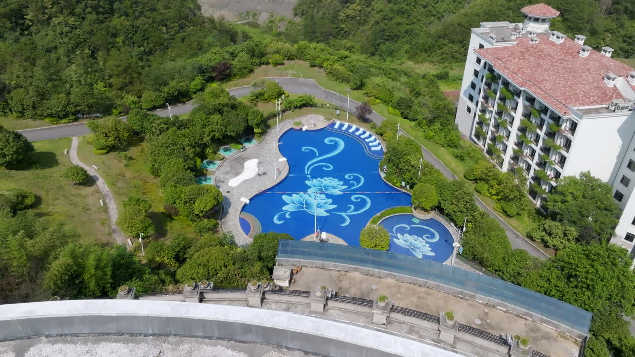 Aerial view orbiting a swimming pool decorated with flowers, sunny day in China