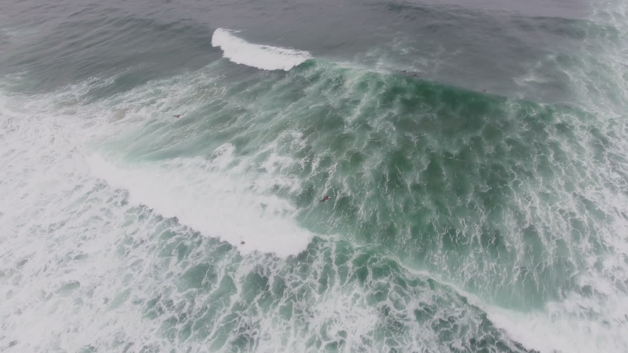 남아프리카 공화국의 커피 베이에서 서핑하는 서퍼 위로 날아가는 공중 액션 시네마틱