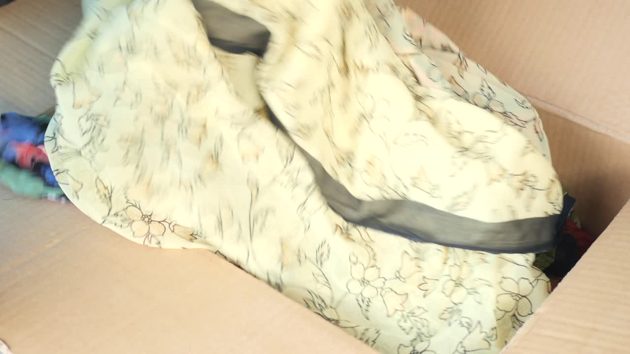 여자 가 상자 에 옷 을 포장 하고 있다