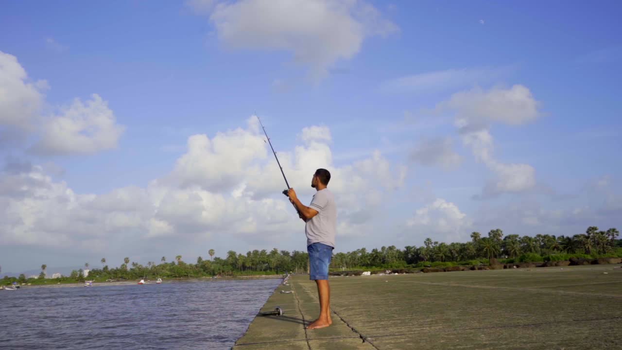 boy fishing on beach slow motion with a fishing rod