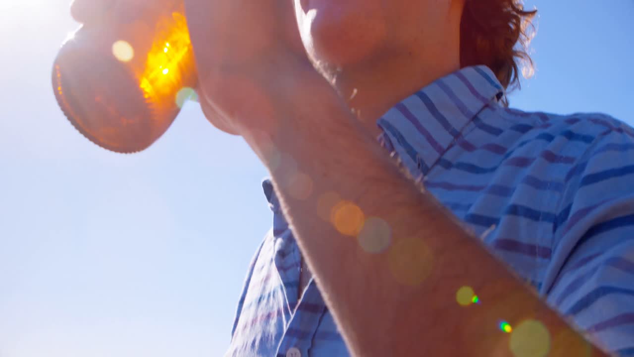hombre tomando cerveza en la playa 4k