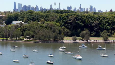 urban skyline viewed over a tranquil bay dotted with sailboats, a perfect blend of nature and city life