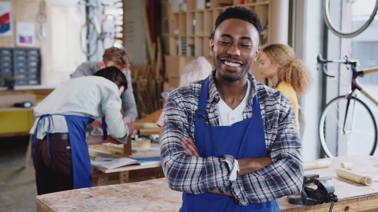 Portrait Of Male Small Business Owner In Workshop Assembling Hand Built Bamboo Bicycles